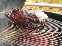 a pork shoulder on a charcoal grill