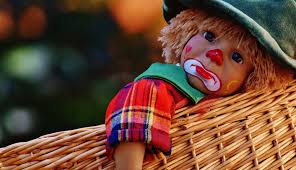 sad clown doll in basket free stock photo
