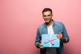 101 best gifts for young men in their 20s … перевести эту страницу. Young Man Holding Gift And Smiling At Camera On Pink Background Free Stock Photo And Image