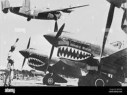 China: American Liberator bomber flies over Flying Tiger P-40 fighters,  Kunming, c. 1942. Flying Tigers was the popular name of the 1st American  Volunteer Group (AVG) of the Chinese Air Force in