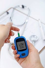 Hand Holding A Blood Glucose Meter Measuring Blood Sugar