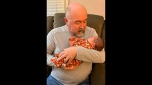 grandpa meets his baby grandson for the