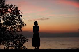 silhouette of a woman standing alone at