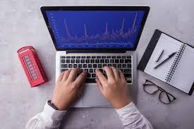 Top Of Businessman Using Laptop Computer With Stock Chart