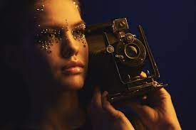 rhinestone makeup poses with a retro camera