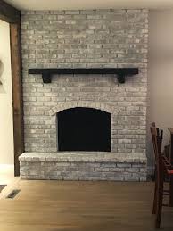Whitewashed Fireplace With Black Mantel