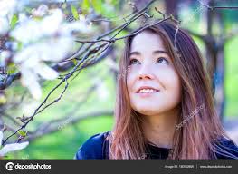 beautiful without makeup in a blooming garden woman with long hair without makeup natural beauty without makeup a is smiling in a magnolia