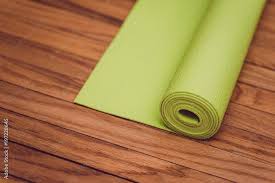 green yoga mat on wooden floor