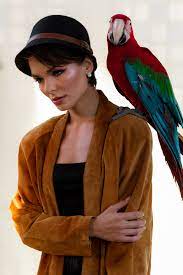 woman with stylish makeup and parrot on