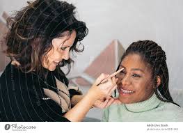 makeup artist correcting eyebrows of