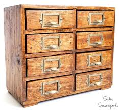 This catalog is wood with a standard rectangular design and metal handles. Tabletop Version Of A Vintage Library Card Catalog