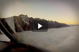 Fly A Curved Approach Through Clouds And Mountains In New