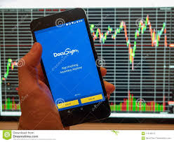 Docusign Mobile App Held In Front Of A Stock Price Chart On