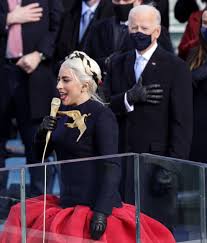 Gaga's outfit also featured matching gloves and her jewelry included a large golden dove brooch to symbolize peace and unity. Lady Gaga Hunger Games Inauguration