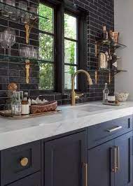 In a kitchen designed by soler architecture and design, black and white cabinets are set off with black marble countertops. Fotografiya Kitchen Design Interior Design Kitchen Dark Blue Kitchens
