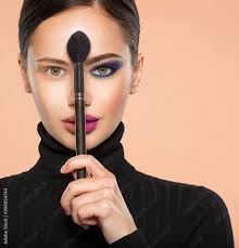 face woman holds a big makeup brush