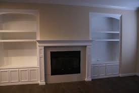 white fireplace mantel and bookcases in