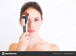 young lady holding makeup brushes