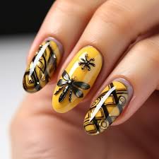 a woman s nails with a bee design on it