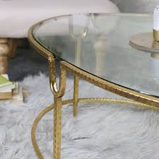 large gold oval glass topped coffee table