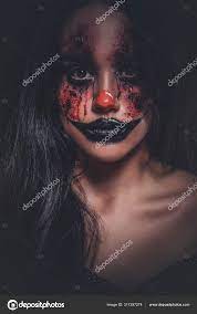 evil creepy clown at dark photo studio