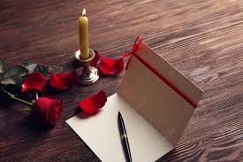 Tarjeta de regalo para el día de san valentín con pluma de pétalos rojos y  velas sobre fondo de madera | Foto Premium
