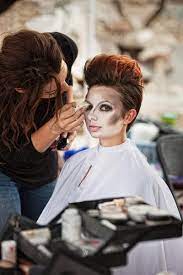 makeup artist paining clown face stock