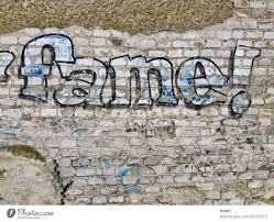 Fame Graffiti On Light Brick Wall