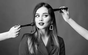 pretty woman applying makeup brush