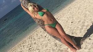 Med hennesslank kropp og Mørkeblond hårtype uten BH (BH-størrelse 34B) på stranda i bikini
