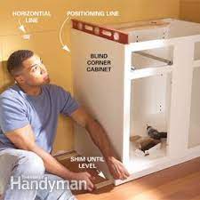 Place the corner cabinet starting with a corner, use the guides you marked on the walls to transfer the stud locations to the cabinets, taking care to account for the face frame. How To Install Kitchen Cabinets Diy Family Handyman