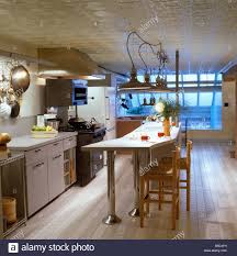 Pendant Lights Above Breakfast Bar With Wooden Stools In