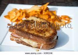 Ham and swiss on sourdough. Toasted Sourdough Ham And Cheese Sandwich Bread Grilled Cheese Sandwich Hold Together By A Topic And Served With Bbq Chips On A Square White Plate Stock Photo Alamy
