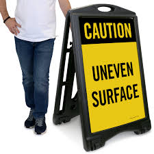 caution uneven surface sidewalk sign