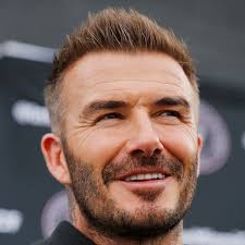 David beckham looks chiseled while sitting shirtless on his kitchen floor as he attempts to train his puppy to give the paw. David Beckham Olympics Com