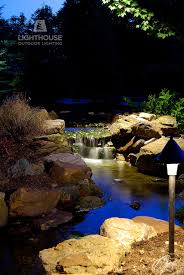 A Single Low Voltage Down Light Hanging From A Limb Illuminates This Backyard Stream And Waterfall Landscape L Outdoor Landscape Lighting Waterfall Landscape