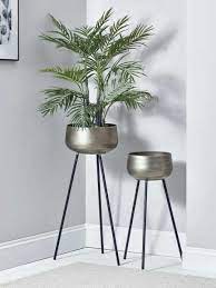 two brushed gold standing planters