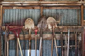 Garden Tools Hanging In A Row In A Shed