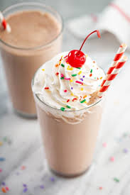 chocolate frosty with whipped cream sprinkles and a cherry