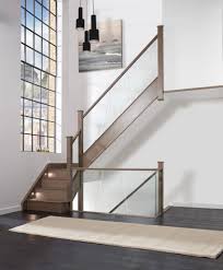 Frameless glass bannister face fixed to timber staircase with a stainless steel handrail fixed to both the glass and the upper section of wall. Glass Staircases Glass Banisters Glass Railings Neville Johnson