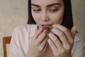 crop woman applying lipstick on lips