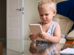 cute baby looking at smart phone stock