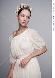 woman in white greek dress with flowers