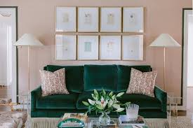 emerald green velvet sofa on pink wall