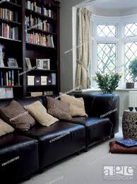 black leather sofa with cream cushions