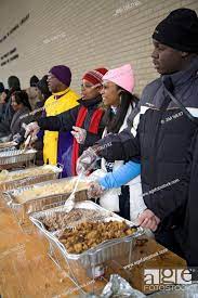 volunteers serve food to the hungry at