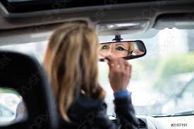 woman applying make up in car stock