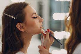 beautiful young woman applying makeup