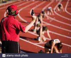 Race official holding a starting gun at the beginning of a track event  Stock Photo - Alamy
