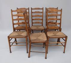 The classic version features a high back and a woven rush seat. A Set Of Six Oak Clissett Ladder Back Dining Chairs By William Bir The Millinery Works